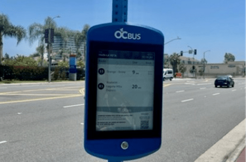 A digital sign posted at an OC Bus Stop